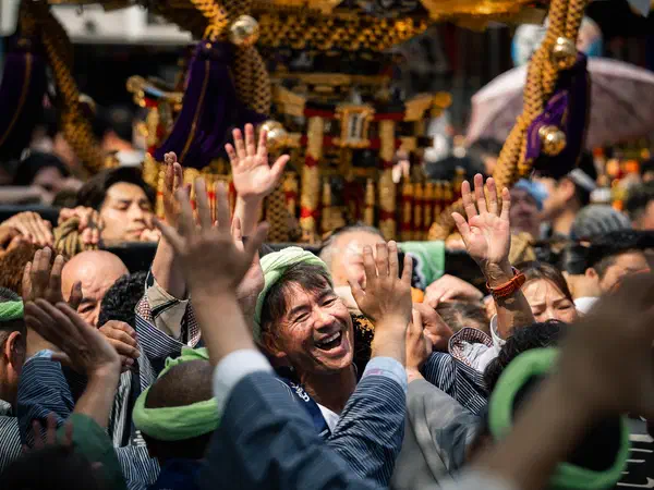 Photography: Hands reaching for a mikoshi as it passes through the crowd.